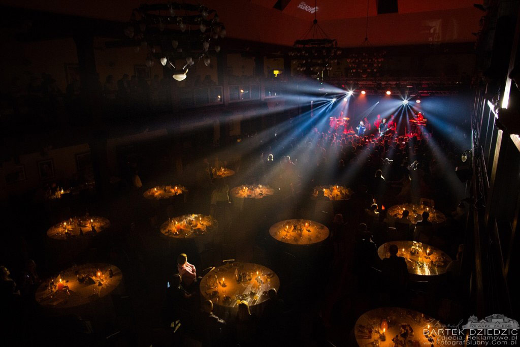 Fotografia reklamowa Bartek Dziedzic Folwark Zalesie Sala Manez ośiwetlona światłem ze sceny podczas koncertu.