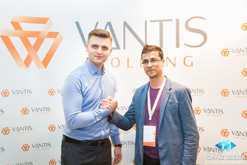 Prezes Vantis Holding Piotr Sołtys wraz z uczestnikiem konferencji. Zdjęcie zostało wykonane Teleobiektywem na świetle zastanym.