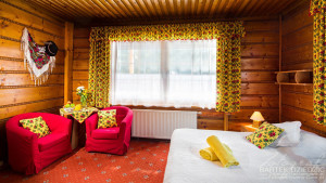 Fotograf Zakopane. Zdjęcie przedstawia pokój w pensjonacie w stylu góralskim z żółtymi elementami dekoracyjnymi.