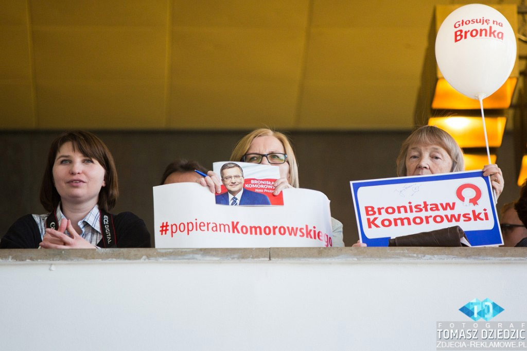 Spotkanie wyborcze Prezydenta Bronisława Komorowskiego w NCK. Osoby trzymają plakaty i wizytówki prezydenta