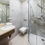 Fotograf do zdjęć hotelu w Krakowie. Łazienka z prysznicem, toaletą, i umywalką.